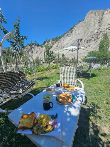 a picnic table with a plate of food on it at Escape Hostel in Karimabad Hunza