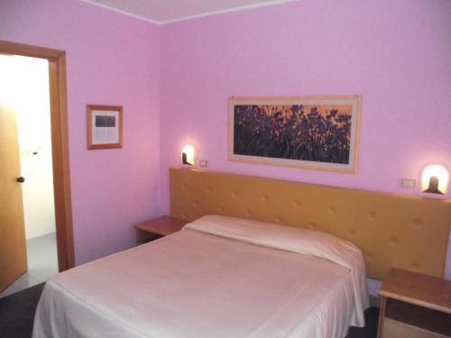 a bedroom with purple walls and a bed in it at Hotel Ristorante alla Campagna in San Giovanni Lupatoto