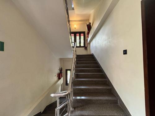 a staircase in a house with a metal handrail at Collection O GNRC Hospital Dispur Formerly Shree Vinayak Guest House in Guwahati