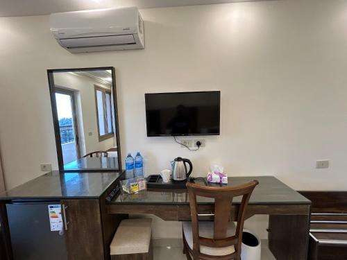 a room with a desk with a television and a mirror at Petra Brothers in Petra