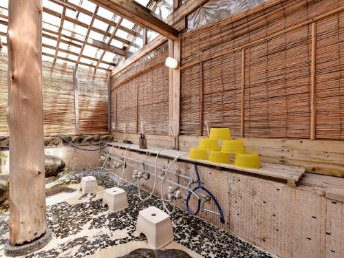 a bathroom with wooden walls and a sink with yellow toilets at Yumorinoyado Sannozyou in Mogami