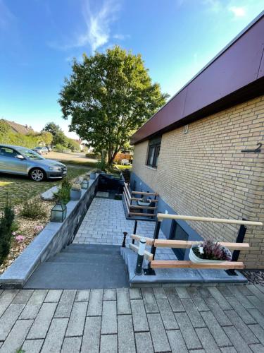 a patio with two benches next to a brick building at Gemütliche Wohnung am Tor zum Schwarzwald in Nagold