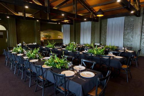 a banquet hall with long tables with plants on them at The Matador in Sale