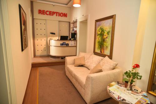 uma sala de estar com um sofá em frente a um salão em Apartments Legacy em Belgrado