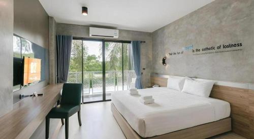 a bedroom with a white bed and a green chair at B2 Krabi Premier Hotel in Ao Nang Beach
