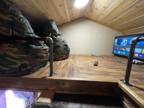 a room with a couch and a tv in it at Tiny Tiny Bunkhouse in Cane Beds
