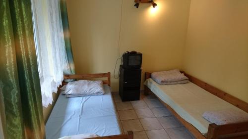 a room with two beds and a tv in it at Ośrodek Wypoczynkowy Duet in Zamość