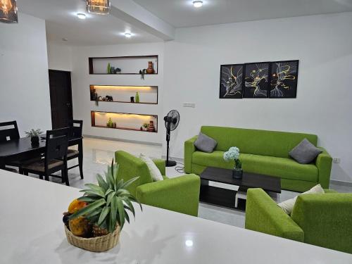 a living room with green chairs and a table at Green Vibe Apartments in Nugegoda