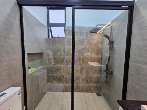 a bathroom with a shower with a glass door at Green Vibe Apartments in Nugegoda