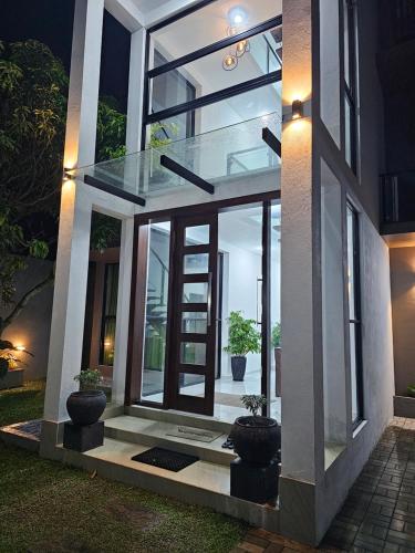 a glass house with two potted plants in front of it at Green Vibe Apartments in Nugegoda
