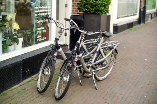 two bikes parked on a sidewalk in front of a store at Hotel Larende in Amsterdam