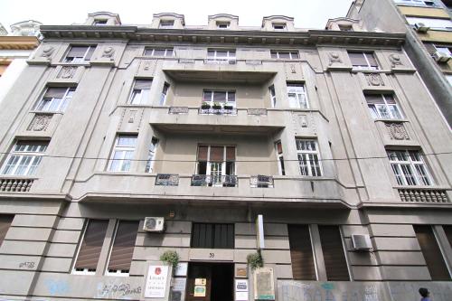 a tall building with windows and balconies on it at Apartments Legacy in Belgrade