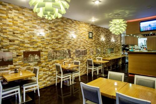 un restaurant avec des tables et des chaises et un mur en briques dans l'établissement Hotel Larende, à Amsterdam