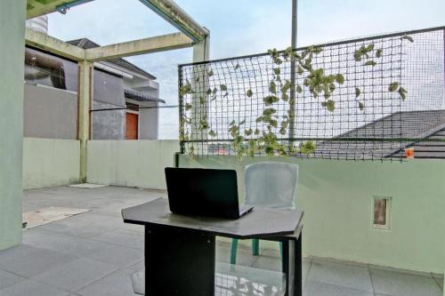 a laptop computer sitting on a desk on a balcony at SPOT ON 91918 Najla Guest House Syariah in Pekanbaru