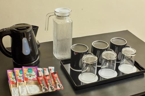 a tray with cups and a coffee maker on a counter at Summit Hotel Tacloban in Tacloban