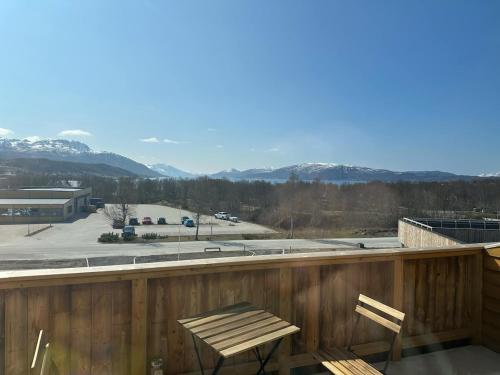 a balcony with two chairs and a view of the mountains at Helt ny sentral 2-roms leilighet i Dyrøy in Brostadbotn