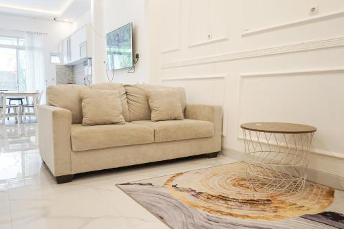 a living room with a couch and a table at Griya Mahoni Palagan Homestay Jogja in Ngaglik