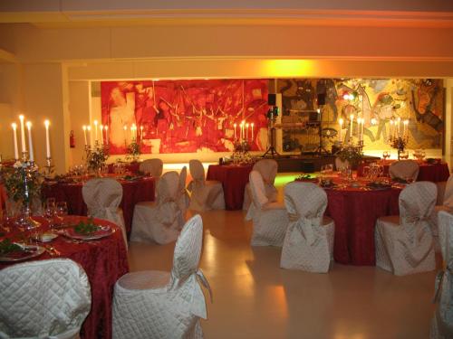 a banquet hall with tables and chairs and candles at Wall Art Hotel & Residence in Prato