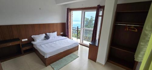 une chambre avec un lit et une fenêtre avec un balcon dans l'établissement Opal Villas, à Mussoorie
