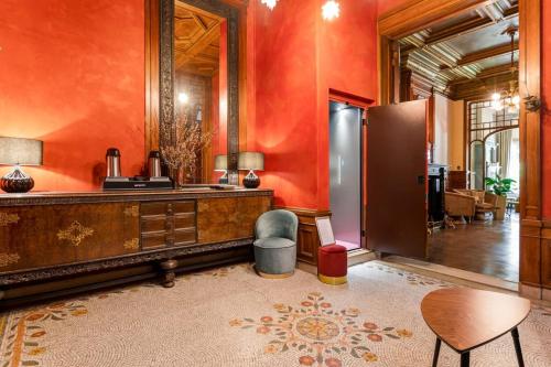 a living room with orange walls and a table and chair at Boutique Baron Osy Suite First Terrace in Antwerp