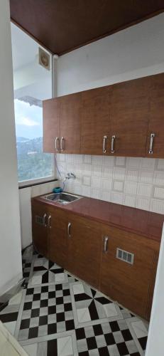 a kitchen with a sink and a checkered floor at Opal Villas Mussoorie near Mall Road in Mussoorie