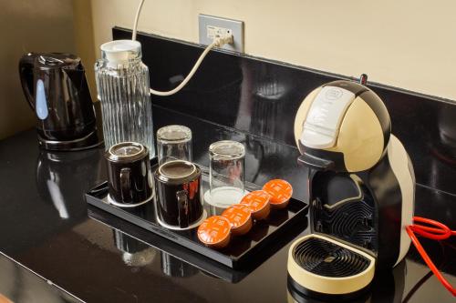 a coffee maker sitting on a black counter with food at Summit Hotel Tacloban in Tacloban