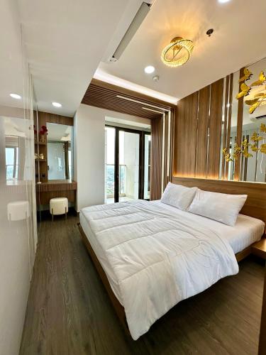 a bedroom with a large white bed in it at Asha suite by Patraland Amarta Apartemen in Kejayan