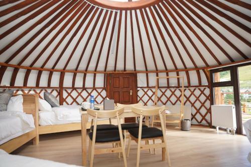 une yourte avec une table, des chaises et un lit dans l'établissement Premium Bolor Resort, Terelj, à Nalayh