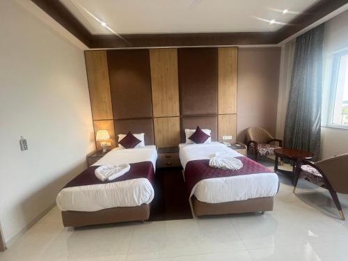 a hotel room with two beds and a window at Nirvana Grand Hotel & Resort in Gaya