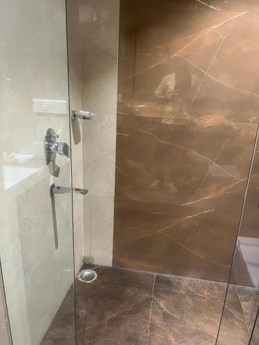 a shower with a glass door in a bathroom at Nirvana Grand Hotel & Resort in Gaya