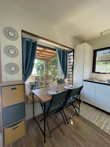 a kitchen with a table and chairs in a room at Le Tahiti Bungalow Surf Lodge in Haapape
