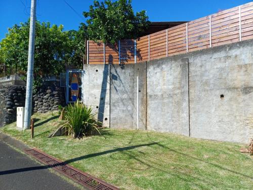 a concrete wall with a fence on top of it at Le Tahiti Bungalow Surf Lodge in Haapape