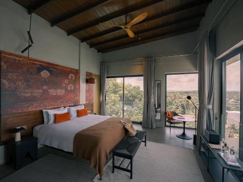 a bedroom with a bed and a large window at NiiRA in Mirissa