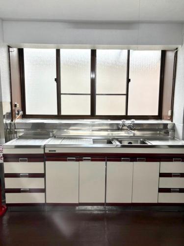 a kitchen with a sink and a window at 御太刀屋 in Oishi