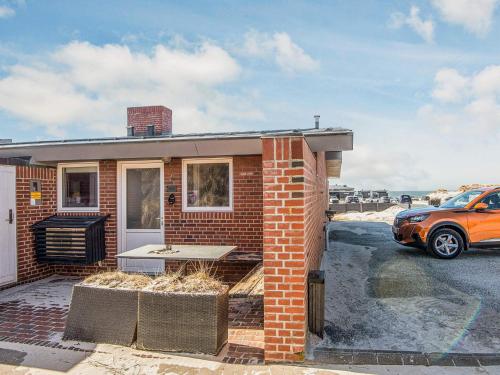 a brick house with a car parked in a parking lot at 4 star holiday home in Henne in Henne Strand