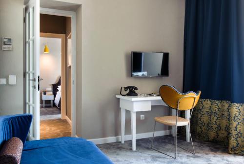 a room with a desk and a tv on a wall at XII Century Heritage Hotel in Trogir
