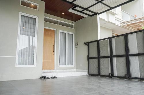 an empty room with a door and two windows at Griya Mahoni Palagan Homestay Jogja in Ngaglik