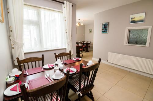 uma sala de jantar com uma mesa de madeira e cadeiras em O Neills Bed and Breakfast em Dingle