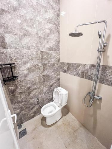 a bathroom with a toilet and a shower at Griya Mahoni Palagan Homestay Jogja in Ngaglik