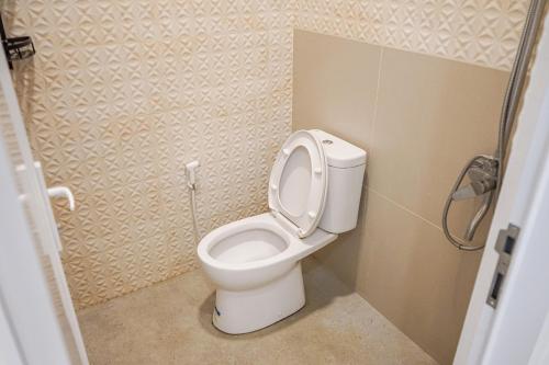 a bathroom with a toilet with the lid up at Griya Mahoni Palagan Homestay Jogja in Ngaglik