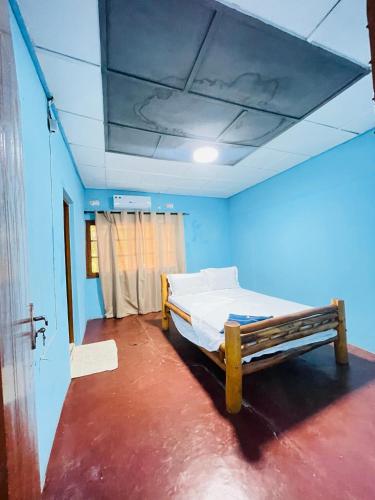 a bedroom with a bed in a blue room at Bush Beach Backpackers in Vilanculos