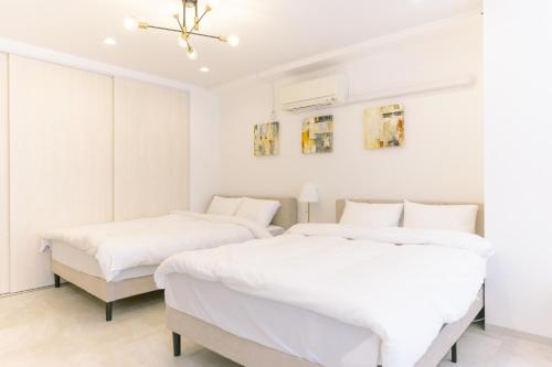 two beds in a bedroom with white walls at 8min walk from Shibuya Sta in Tokyo