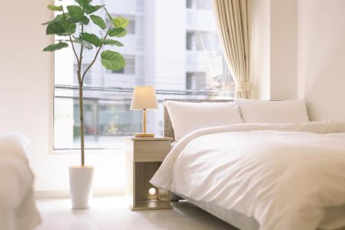 a bedroom with a white bed and a window at 8min walk from Shibuya Sta in Tokyo