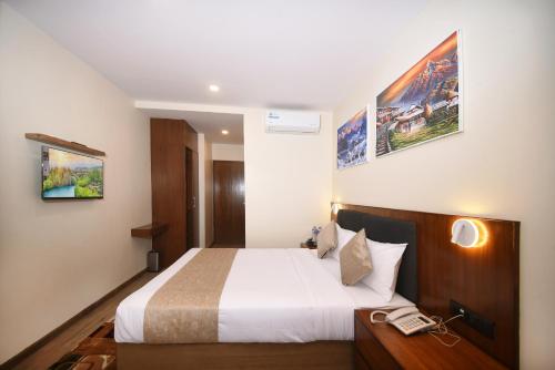 a hotel room with a bed and a phone at Hotel Cozy Heaven in Kathmandu
