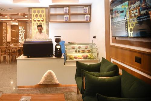 a restaurant with a man behind the counter of a store at Hotel Cozy Heaven in Kathmandu