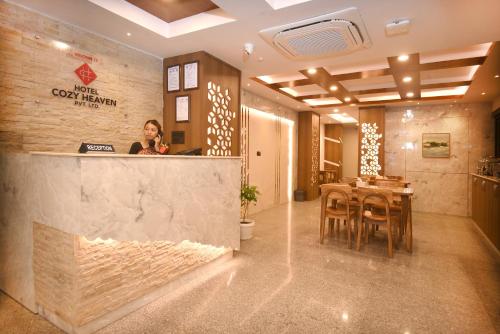 a man sitting at the counter of a restaurant at Hotel Cozy Heaven in Kathmandu