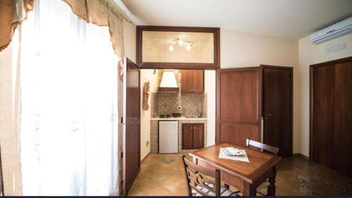 a kitchen with a wooden table and a dining room at B&B Marchese SantAndrea in Licata