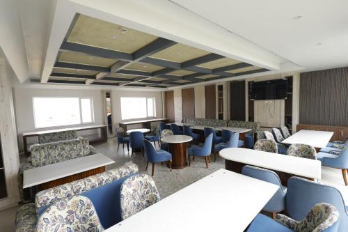 a waiting room with blue chairs and tables at Nirvana Grand Hotel & Resort in Gaya