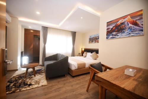 a hotel room with a bed and a desk at Hotel Cozy Heaven in Kathmandu