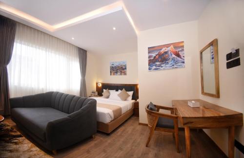 a hotel room with a bed and a couch and a table at Hotel Cozy Heaven in Kathmandu